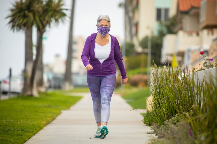 REDONDO BEACH, CA --APRIL 02, 2020 -Joan Irvine, who says she's "over 65," fashioned her own face covering with a bandana and hair ties, for her walk along the Eslplanade, in Redondo Beach, CA, during the coronavirus pandemic and current safer-at-home orders from California Gov. Gavin Newsom, April 02, 2020. Irvine, lives in south Redondo Beach, says she's single and isolating and says getting out and being physically active is more important than ever. (Jay L. Clendenin / Los Angeles Times)