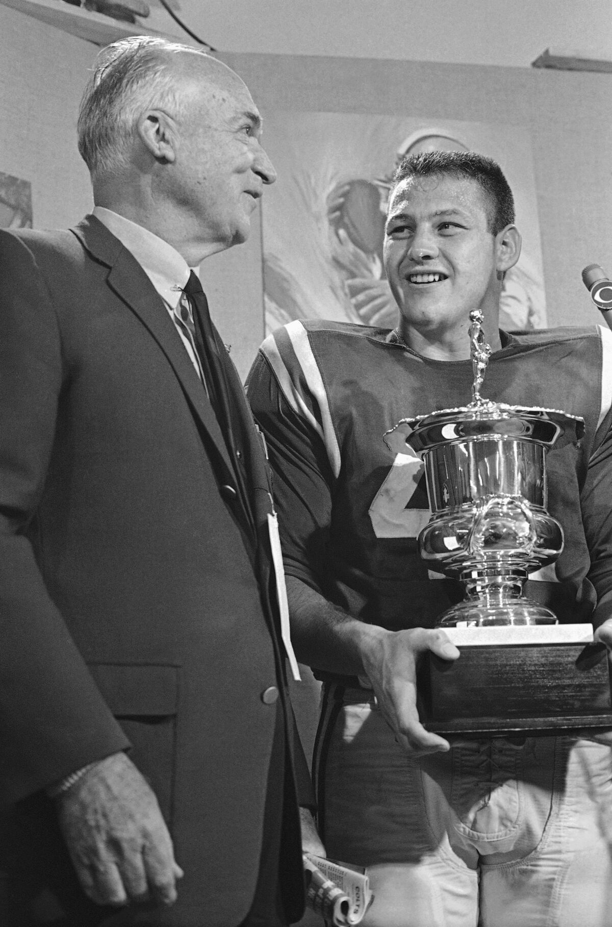 FILE - Van C. Kussrow, left, from the Orange Bowl Committee, presents Baltimore Colts quarterback Tom Matte with the Most Valuable Player trophy after the Colts defeated the Dallas Cowboys 53-3 on Jan. 9, 1966, in Miami. Matte, who spent his entire 12-year NFL career as a gritty running back for the Baltimore Colts _ except for a star turn for three games in 1965 as their quarterback _ has died. He was 82. The Baltimore Ravens confirmed Matte's death during coach John Harbaugh's news conference Wednesday, Nov. 3, 2021. No details were provided.(AP Photo/File)