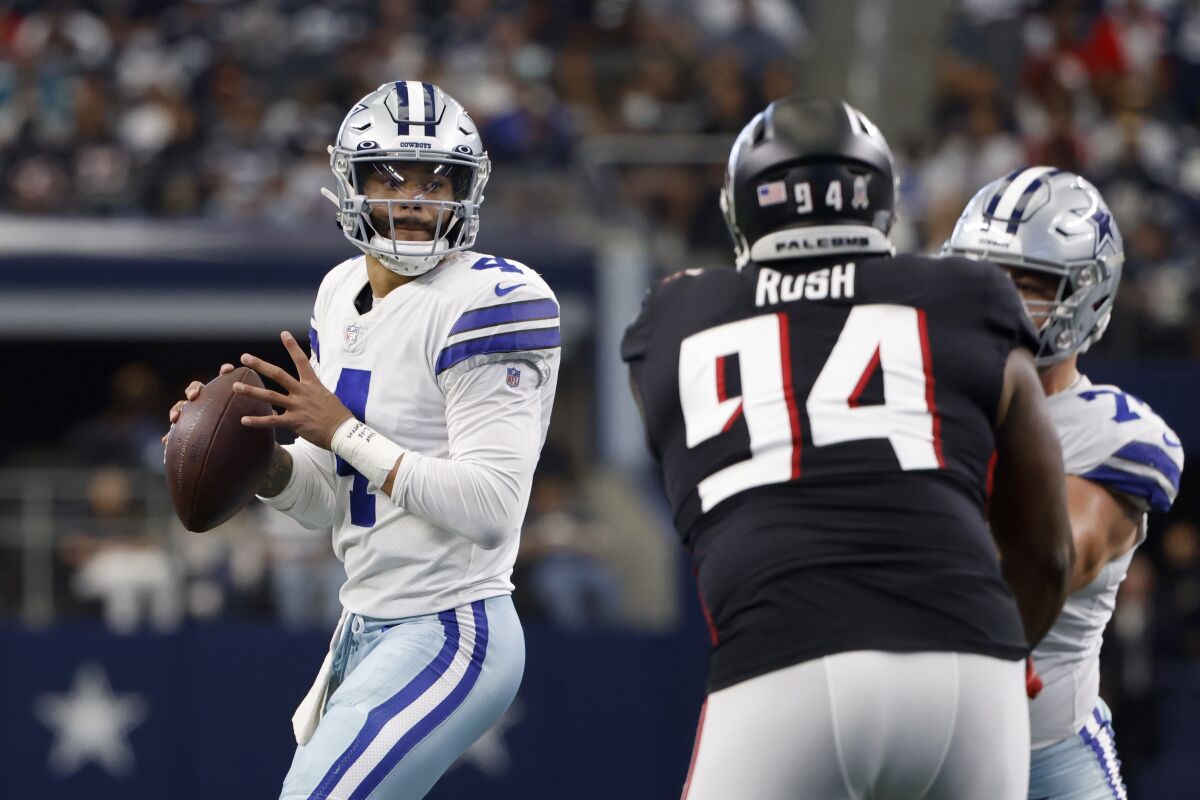 Dallas Cowboys quarterback Dak Prescott (4) prepare to throw a pass under pressure from Atlanta Falcons defensive tackle Anthony Rush (94) in the first half of an NFL football game in Arlington, Texas, Sunday, Nov. 14, 2021. (AP Photo/Ron Jenkins)