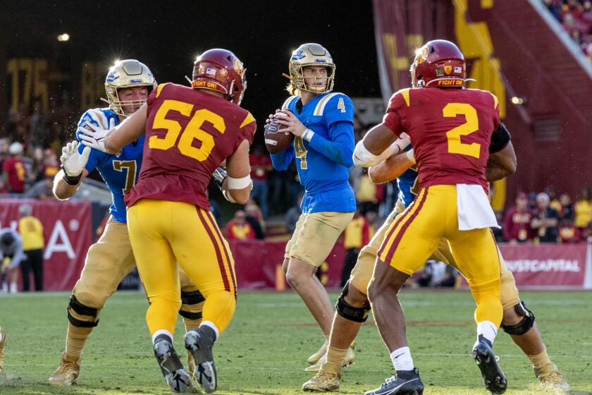 UCLA quarterback Ethan Garbers looks for an open receiver against USC at the Coliseum on Nov. 18, 2023.