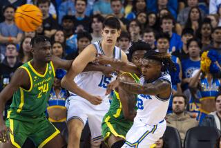 UCLA guard Dylan Andrews, right, passes in front of Oregon's Mahamadou Diawara and UCLA's Aday Mara.