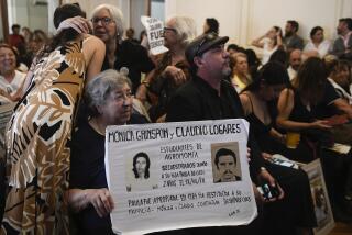 Personas sostienen fotografías de desaparecidos en un tribunal mientras escuchan el veredicto para expolicías y exmilitares procesados por crímenes de lesa humanidad durante la dictadura en La Plata, Argentina, el martes 26 de marzo de 2024. (AP Foto/Gustavo Garello)