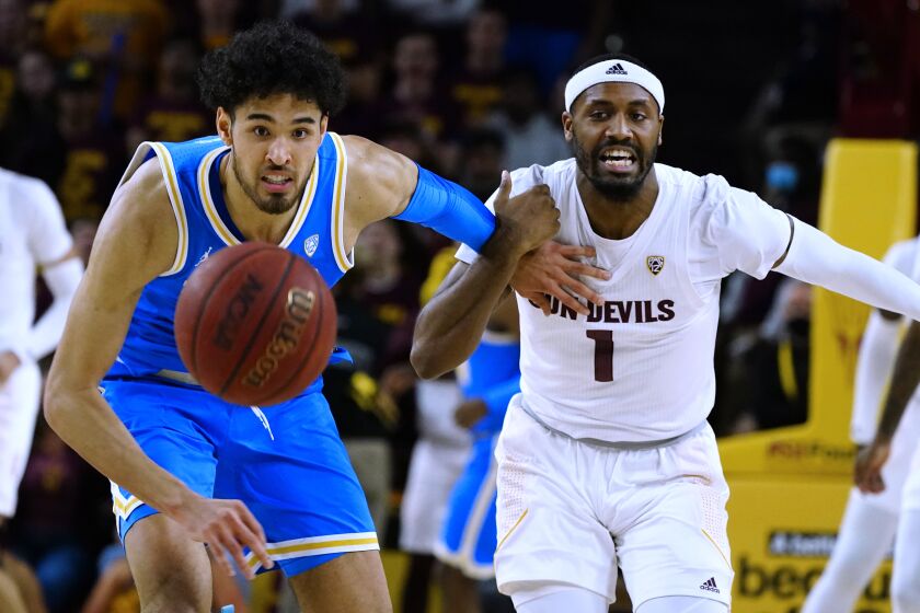 Arizona State guard Luther Muhammad (1) and UCLA guard Johnny Juzang, left, watch the ball bound away during the second half of an NCAA college basketball game Saturday, Feb. 5, 2022, in Tempe, Ariz. Arizona State won in three overtimes, 87-84. (AP Photo/Ross D. Franklin)