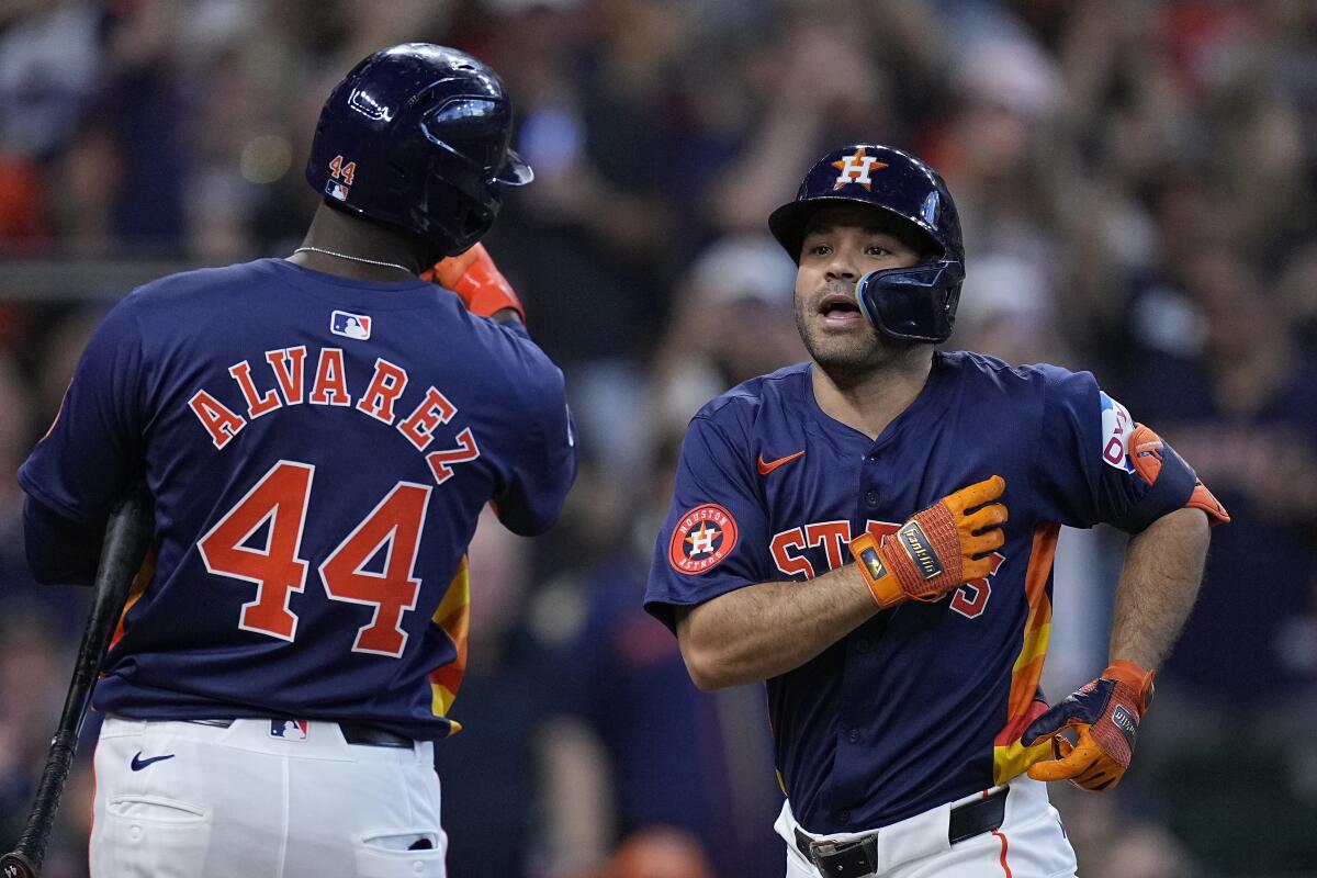 Houston Astros' Jose Altuve, right, celebrates with Yordan Alvarez (44) after hitting a solo home run during the third inning of a baseball game against the Texas Rangers Sunday, April 14, 2024, in Houston. (AP Photo/Kevin M. Cox)