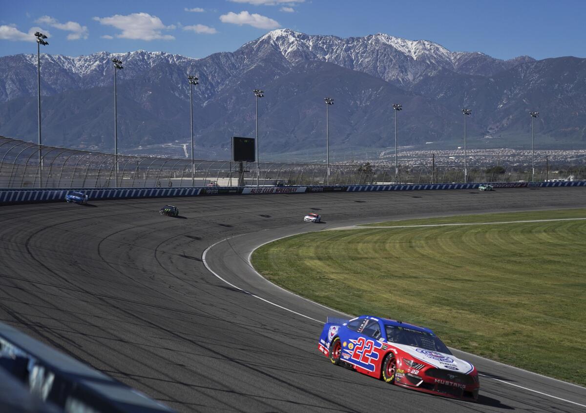 Joey Logano leads during the NASCAR Cup Series auto race at Auto Club Speedway.