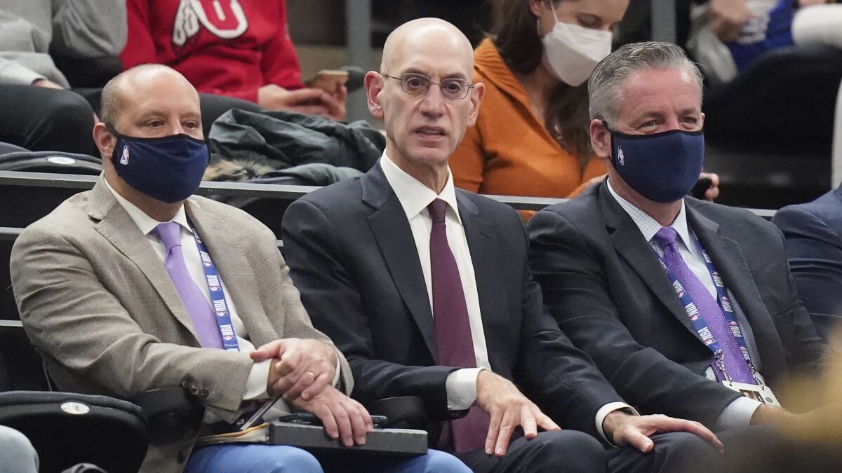 NBA Commissioner Adam Silver, center, looks on in the second half during an NBA basketball game.