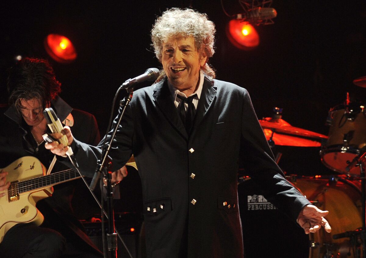 FILE - In this Jan. 12, 2012, file photo, Bob Dylan performs in Los Angeles. The music legend has quietly put concert tickets on sale for a tour in support of last year's album, “Rough and Rowdy Ways.” His website bills it as a “World Wide Tour 2021-2024.” (AP Photo/Chris Pizzello, File)