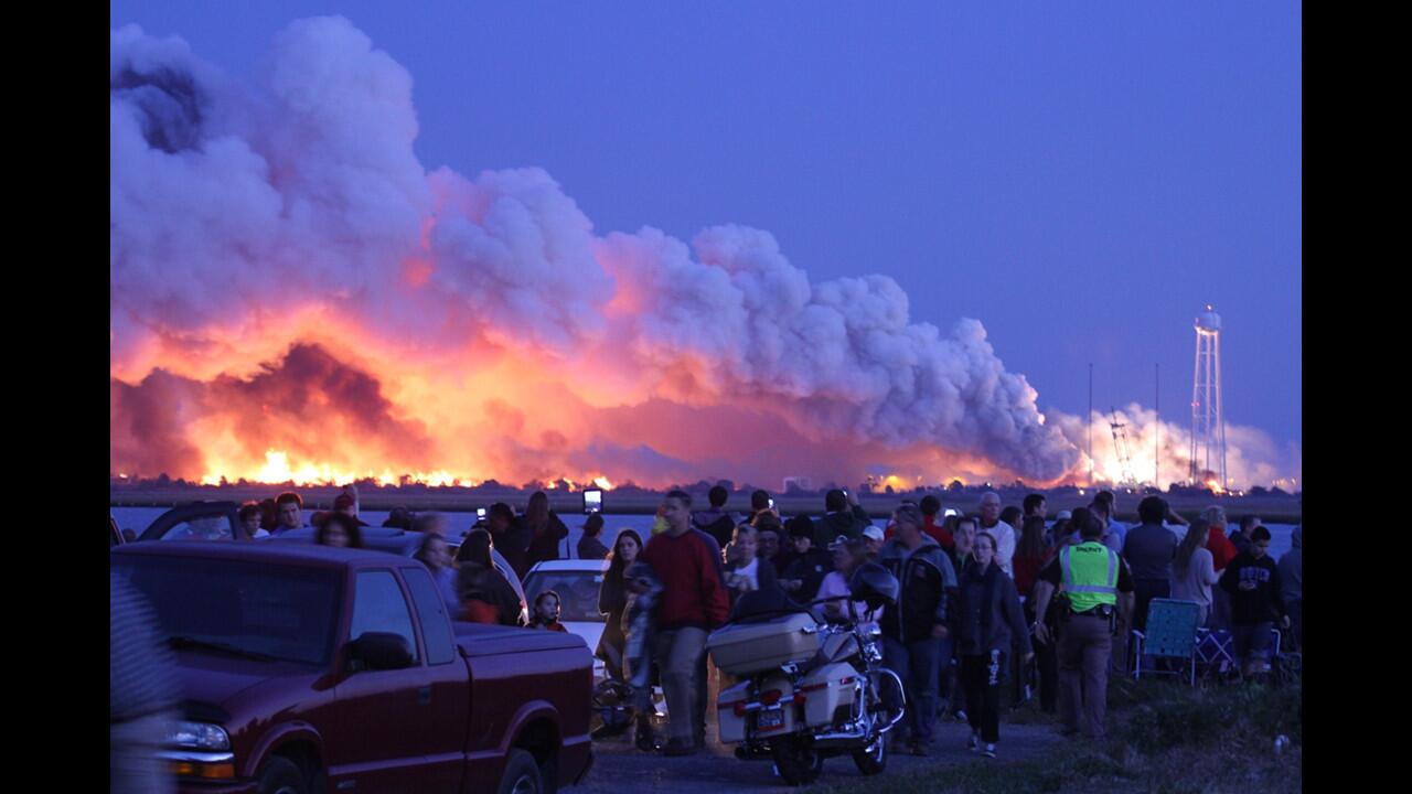 People who came to watch the launch of Orbital Sciences' Antares rocket walk away after it exploded just seconds after liftoff Tuesday from Wallops Island, Va.