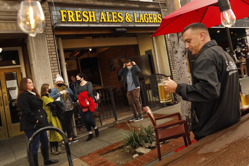 San Pedro, California-Jan. 29, 2021-Despite the weather, a few outdoor diners have returned to downtowns San Pedro. At the San Pedro Brewing Company, people gather after work. Jessie McPherson, right, of San Pedro says "It's a good beginning, but it won't be normal until summer 2022." (Carolyn Cole / Los Angeles Times)