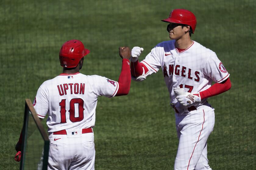 Los Angeles Angels' Justin Upton celebrates with Shohei Ohtani (17) after Upton scored off of a sacrifice fly by Ohtani.