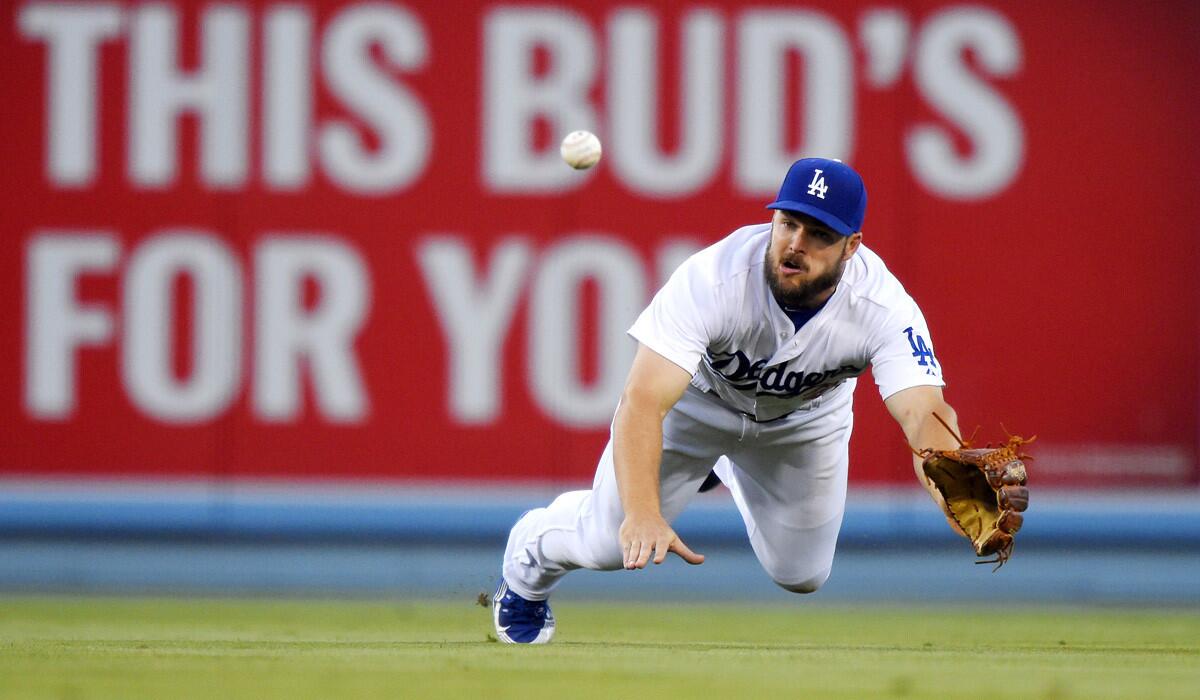 Dodgers outfielder Chris Heisey dives for a ball while playing against the Texas Rangers at Dodger Stadium on June 17.