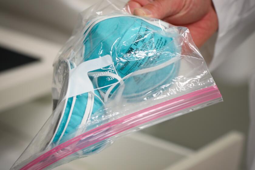 Emergency Medicine Dr. Shawn Evans, at Scripps Memorial Hospital in La Jolla, holds a package of N95 masks, March 24, 2020 in San Diego, California.