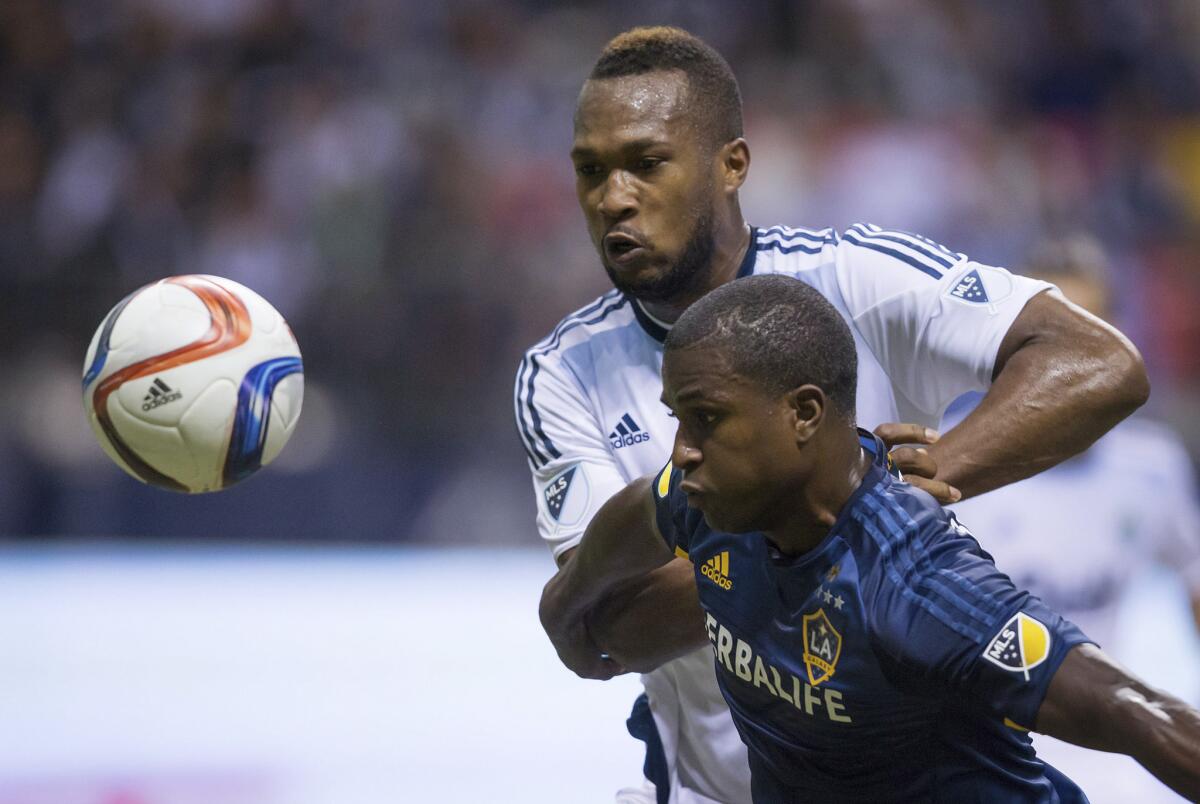 Galaxy forward Edson Buddle and Vancouver defender Kendall Watson chase down the ball during the second half of a game on April 4.