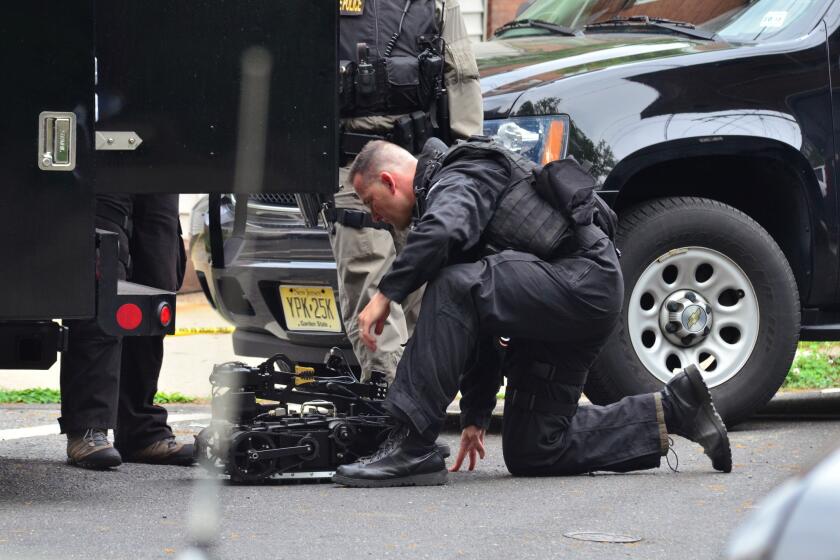 A state police SWAT team member readies a robot to enter a home where a man had barricaded himself in Trenton, N.J.