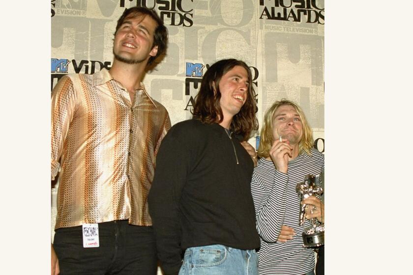 Three men in a band posing with an award