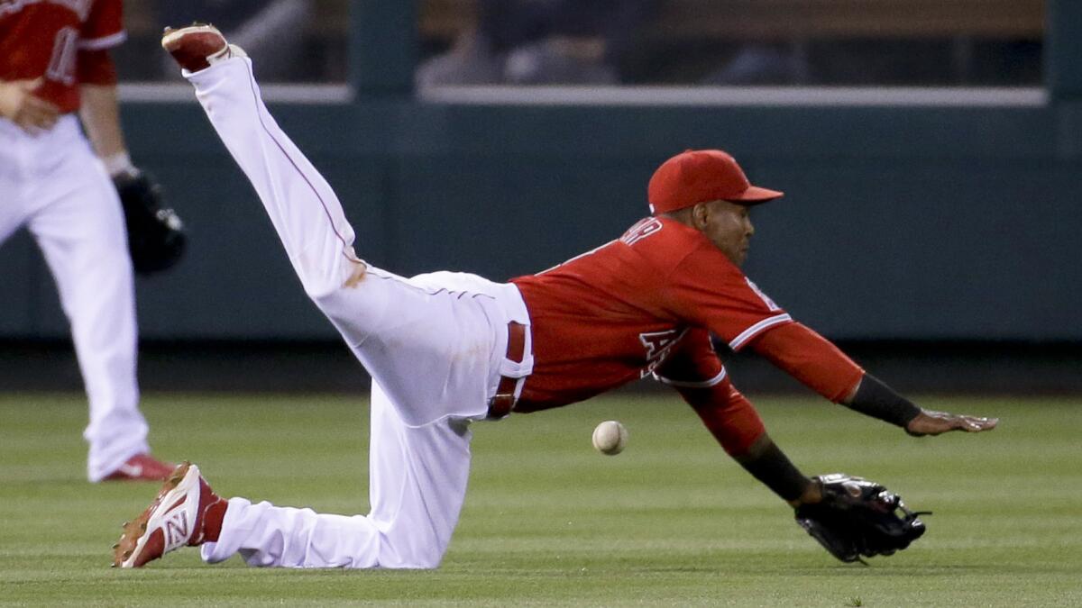 Angels shortstop Erick Aybar, right, can't make a diving stop on a single by Houston Astros designated hitter Chris Carter during the third inning of the Angels' 5-2 loss Monday.