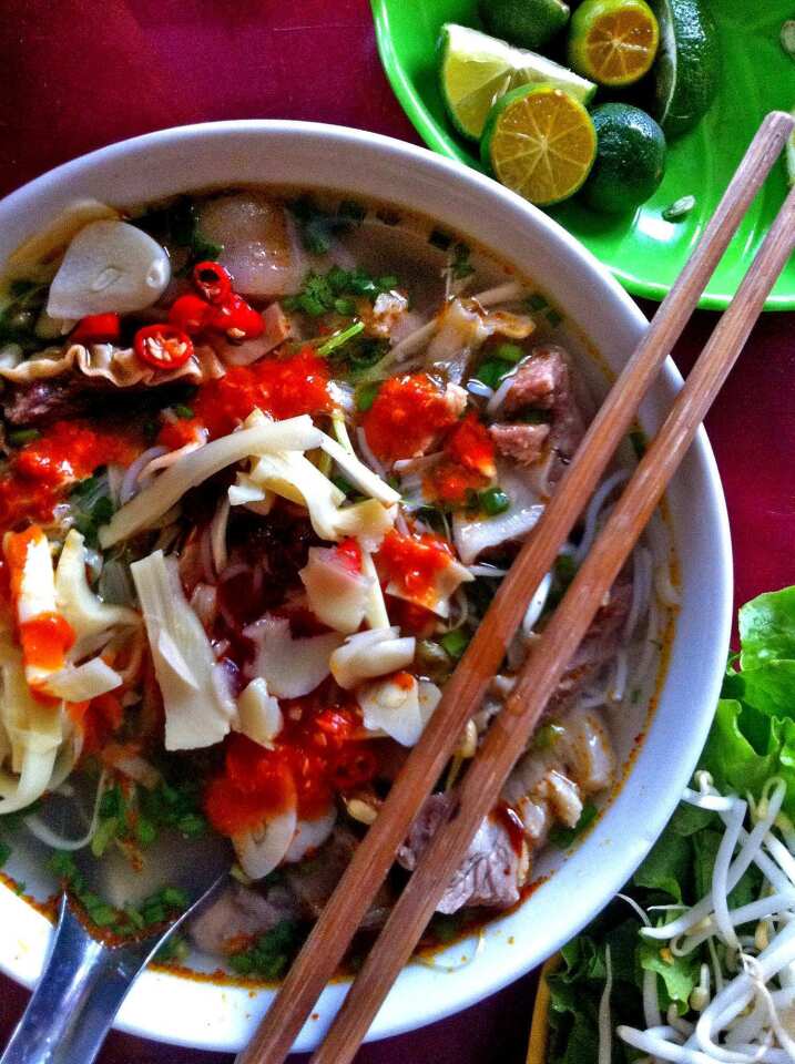 A piping hot bowl of bun cha, from a street stall in Hanoi's Old Quarter. The combination of grilled pork, sweet and savory broth with fish sauce, sliced green papaya, rice noodles and fresh herbs is the signature dish of Hanoi.