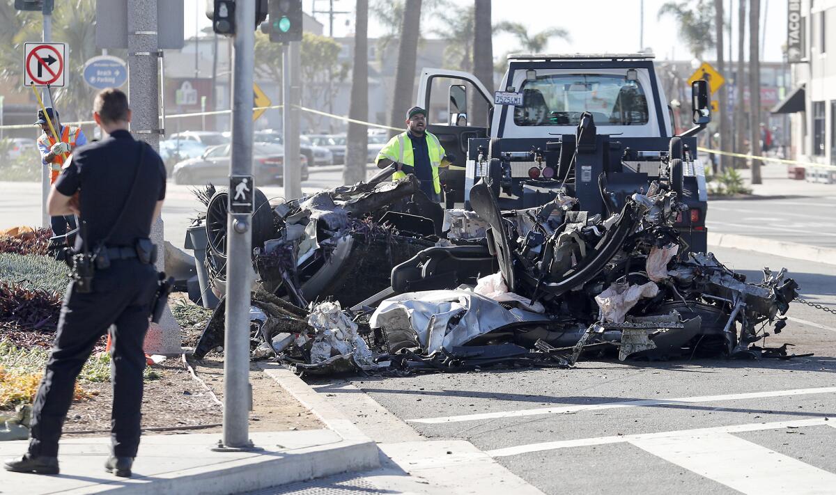 A tow truck driver begins to clear the wreckage of the Mercedes-AMG on Tuesday morning.
