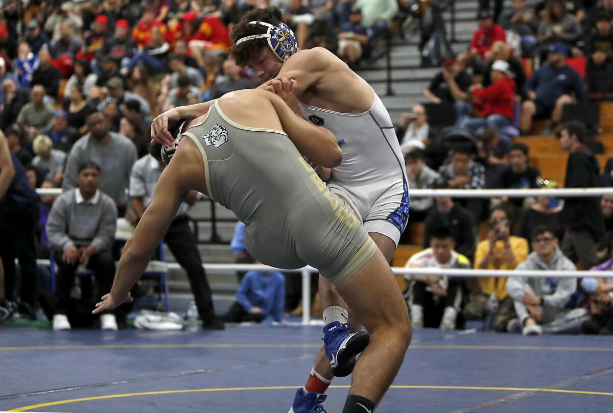 Fountain Valley's Max Wilner sweeps the right leg of Servite's Valor Buck in a 170-pound semifinal match during the Five Counties wrestling tournament at Fountain Valley High on Saturday.