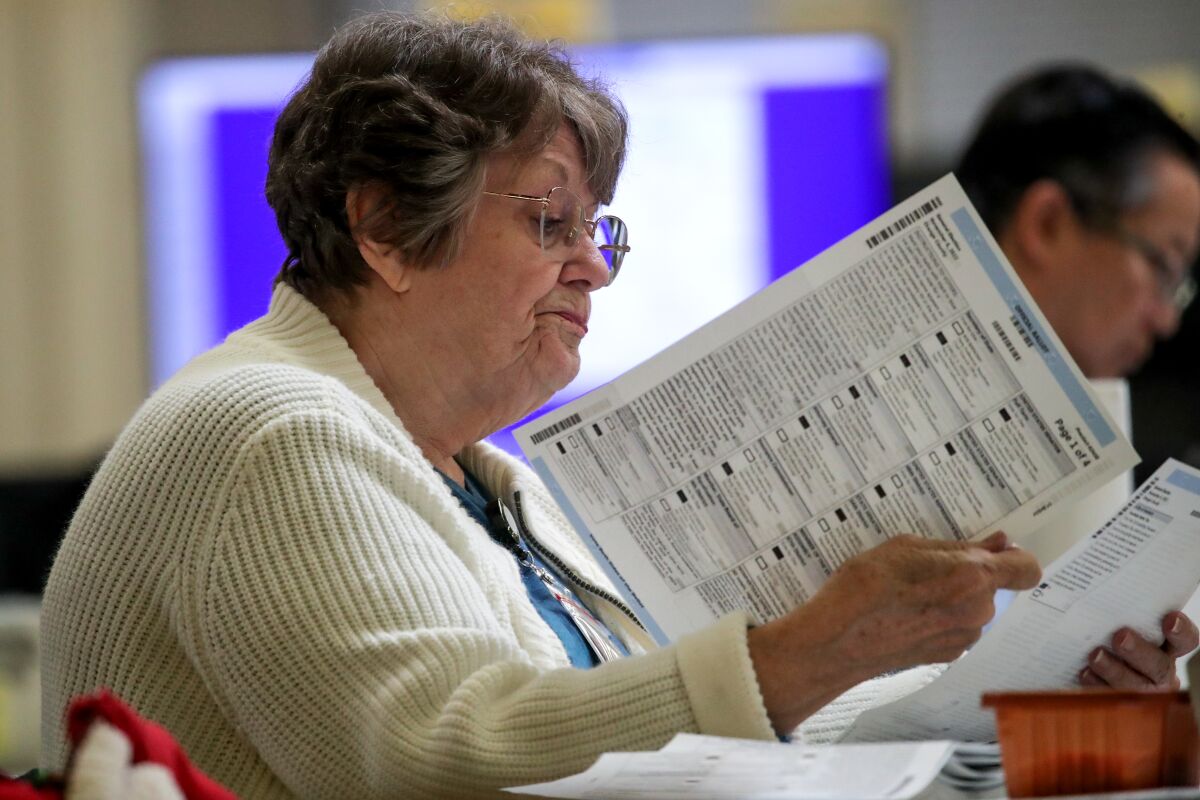 A woman checks the ballots