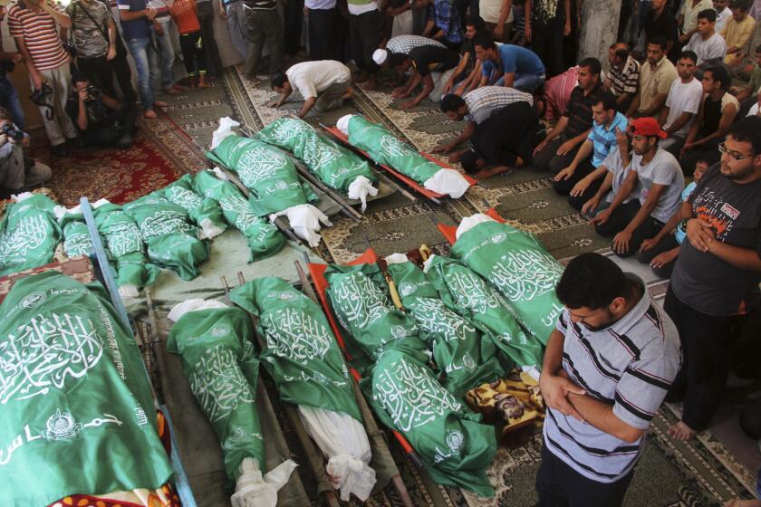 Palestinians pray July 21 over the bodies of a group of family members killed in an Israeli airstrike at their house in the southern Gaza Strip.