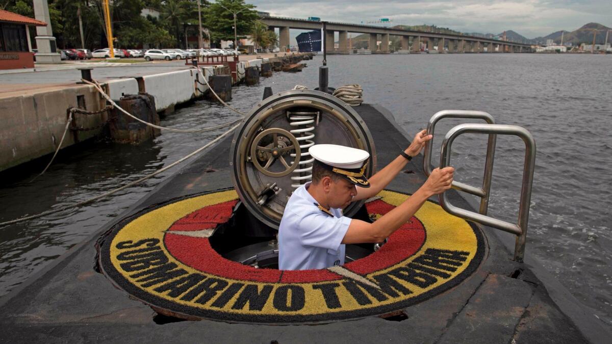 Brazilian navy Capt. Jose Americo Alexandre Dias climbs the hatch of the Brazilian submarine Timbira. Brazil and other nations are taking part in an international search for the missing Argentine submarine San Juan.