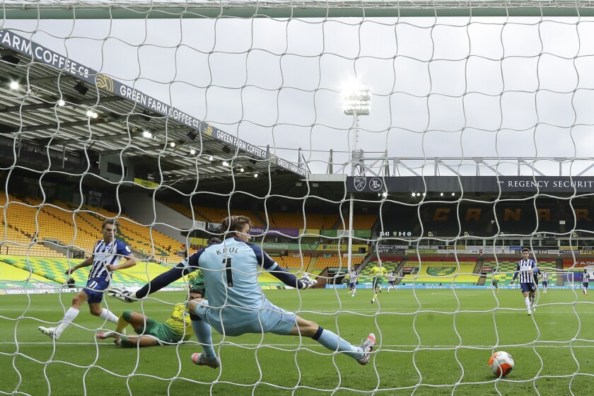 Brighton's Leandro Trossard, left, scores his side's opening goal past Norwich City's goalkeeper Tim Krul during the English Premier League soccer match between Norwich City and Brighton & Hove Albion at Carrow Road Stadium in Norwich, England, Saturday, July 4, 2020. (Richard Heathcote/Pool Photo via AP)