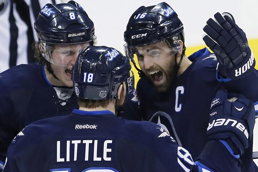 Winnipeg Jets captain Andrew Ladd, right, celebrates with teammates Jacob Trouba, left, and Bryan Little after scoring during a 6-2 win over the Colorado Avalanche on Friday.