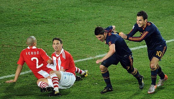 Spain's striker David Villa, second from right, and Spanish midfielder Cesc Fabregas dash past Paraguay's defender Dario Veron, far left, and midfielder Jonathan Santana as they celebrate Villa's goal, which secured Spain's win over Paraguay in a quarterfinal World Cup match at Ellis Park in Johannesburg, South Africa.