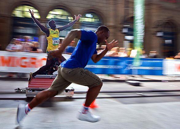 A paperboard Usain Bolt races at world record speed on a 50-meter rail against a challenger at the main railway station in Zurich, Switzerland. The real Jamaican sprinter is in Zurich to attend the IAAF Golden League athletics meeting Friday.