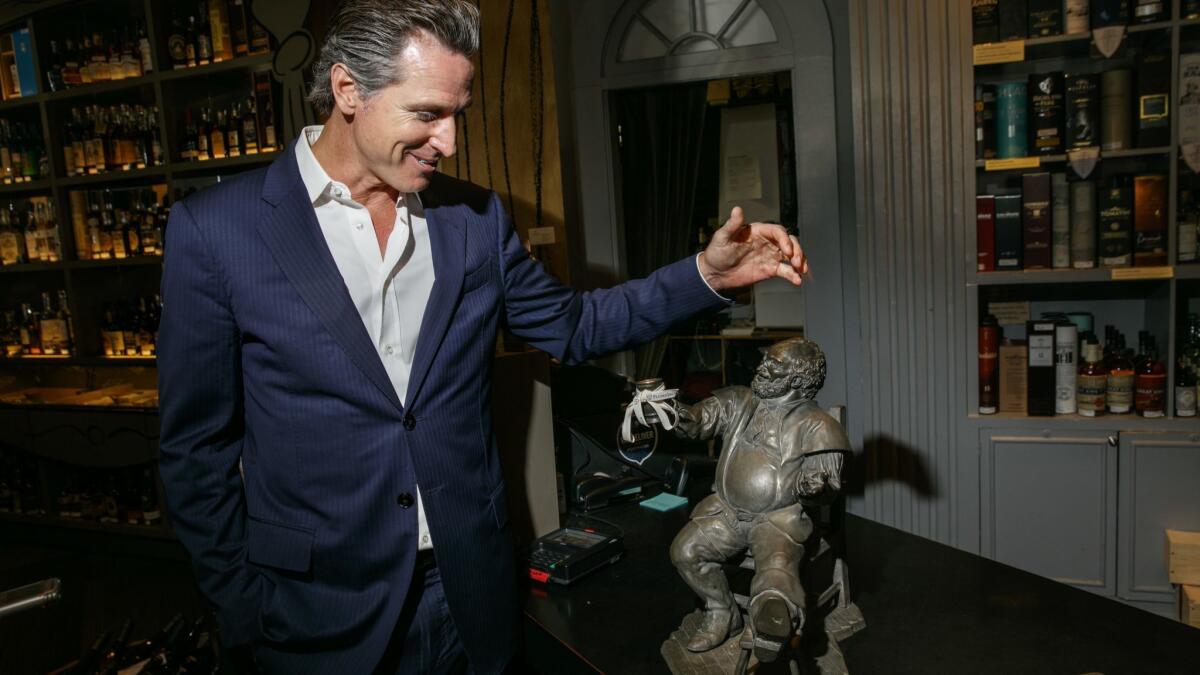 Lt. Gov. Gavin Newsom discusses a statue given to him by the Getty family, which sits in PlumpJack Wine and Spirits, the store he opened in 1992 in the Marina District of San Francisco.