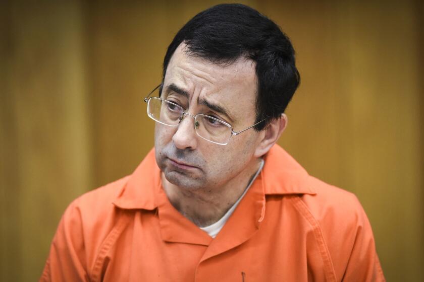 FILE - In this Feb. 2, 2018, file photo, Larry Nassar listens as Melissa Alexander Vigogne gives her victim statement in Eaton County Circuit Court in Charlotte, Mich. The U.S. Olympic Committee has fired chief of sport performance Alan Ashley in the wake of an independent report that said neither he nor former CEO Scott Blackmun elevated concerns about the Larry Nassar sexual abuse allegations when they were first reported to them. The 233-page independent report was released Monday, Dec. 10, 2018. It detailed an overall lack of response when the USOC leaders first heard about the Nassar allegations from the then-president of USA Gymnastics, Steve Penny. Blackmun resigned in February because of health concerns.(Matthew Dae Smith/Lansing State Journal via AP, File)