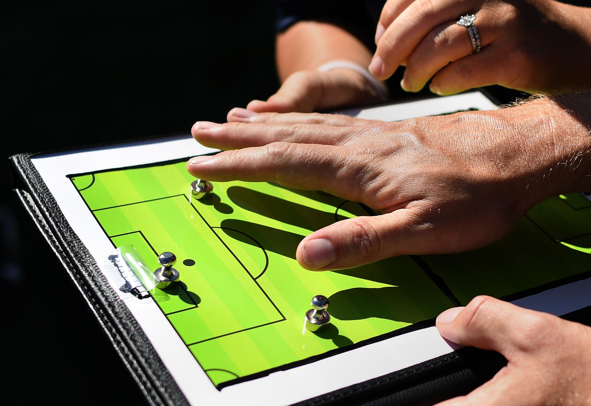 Blind soccer players feel the tactile board during a recent scrimmage at Salt Creek Park in Chula Vista.
