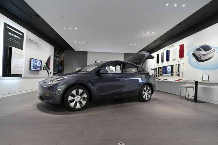 FILE - A Tesla Model Y Long Range is displayed on Feb. 24, 2021, at the Tesla Gallery in Troy, Mich. Tesla has raised prices on its Model Y in the U.S., apparently due to rising demand and changes in U.S. government rules that make more versions of the small SUV eligible for tax credits. (AP Photo/Carlos Osorio, File)
