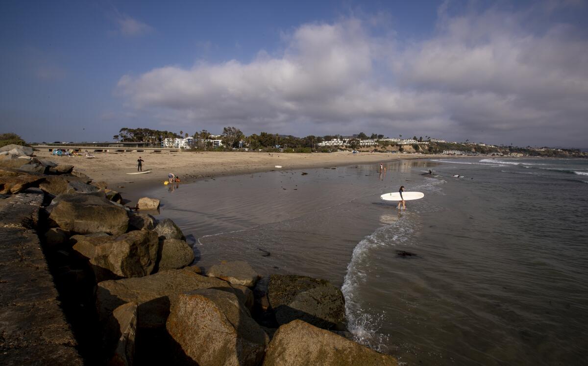 A surfer heads out near the location of the proposed Doheny desalination plant 