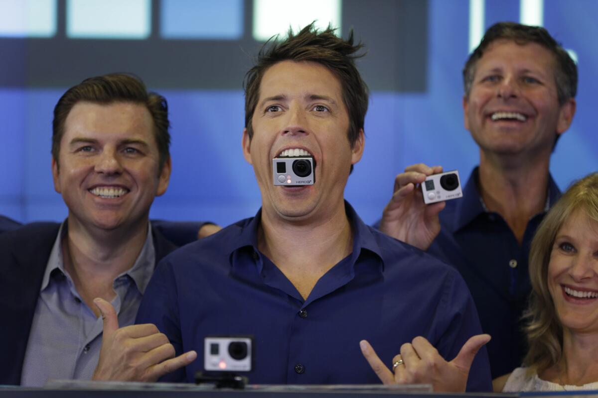 GoPro Chief Executive Nick Woodman, center, is shown at the New York Stock Exchange after the company's June 2014 initial public offering. He hasn't had so much to smile about lately.