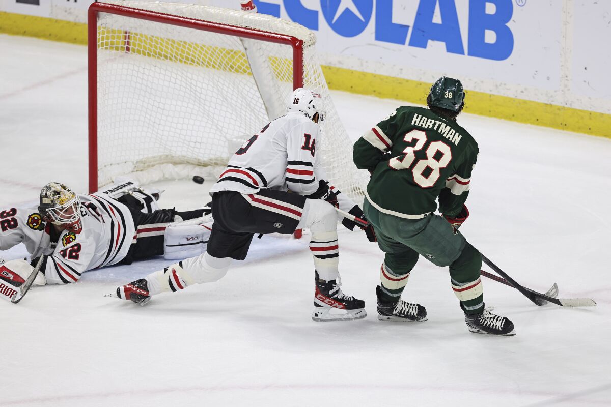 Minnesota Wild right wing Ryan Hartman (38) scores a goal against Chicago Blackhawks goaltender Alex Stalock (32) during the third period of an NHL hockey game Saturday, March 25, 2023, in St. Paul, Minn. Minnesota won 3-1. (AP Photo/Stacy Bengs)