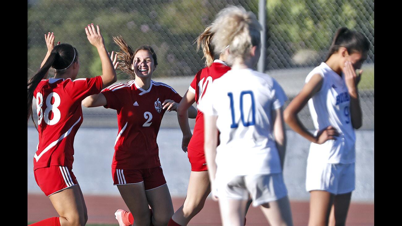 Burroughs High School girls soccer player #2 Samantha Avenado celebrates scoring a goal with #88 Catrina Villalpando in away game vs. Burbank High School at the Bulldog home field in Burbank on Thursday, Feb. 8, 2018.