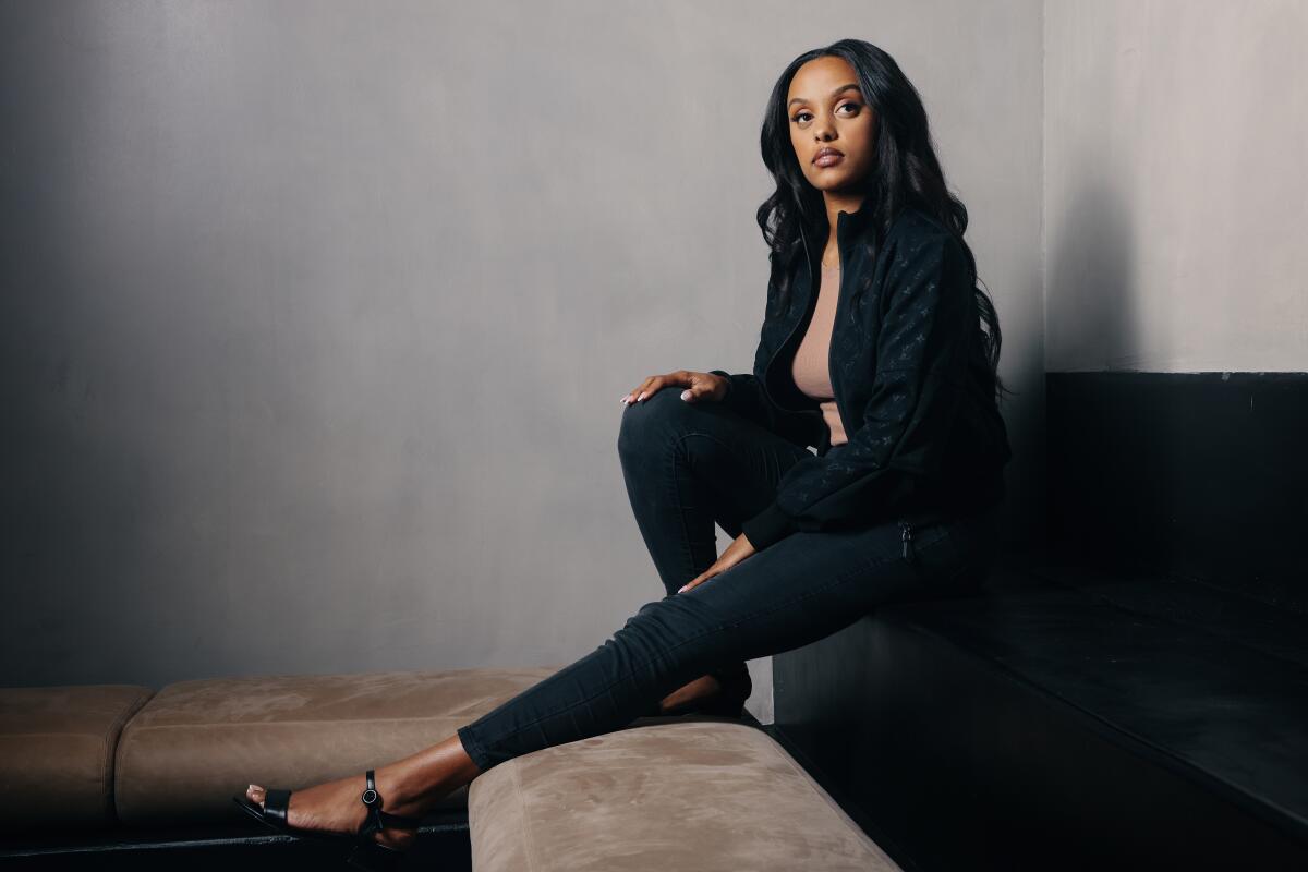 Canadian singer-songwriter Ruth B. sits for a portrait with one leg stretched out in front of her.