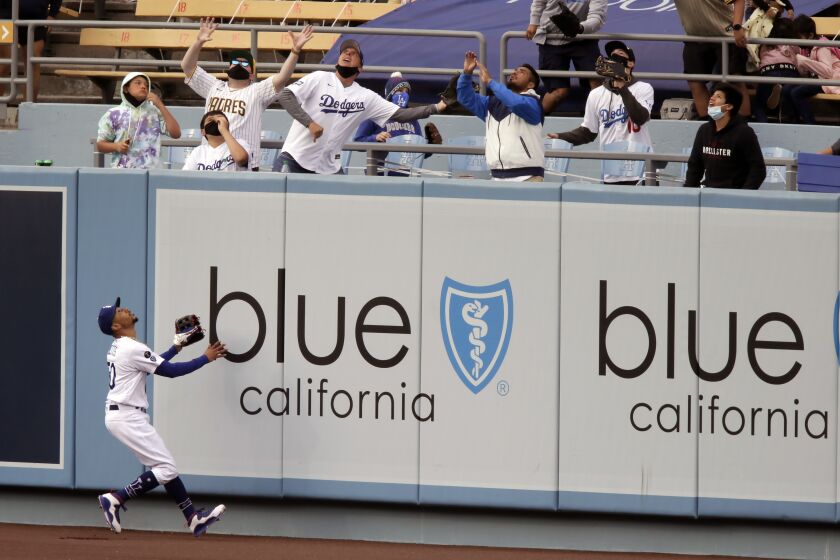 Los Angeles Dodgers center fielder Mookie Betts watches with outfield fans, San Diego Padres' Fernando Tatis Jr. solo home run, during the fourth inning of a baseball game in Los Angeles, Sunday, April 25, 2021. (AP Photo/Alex Gallardo)
