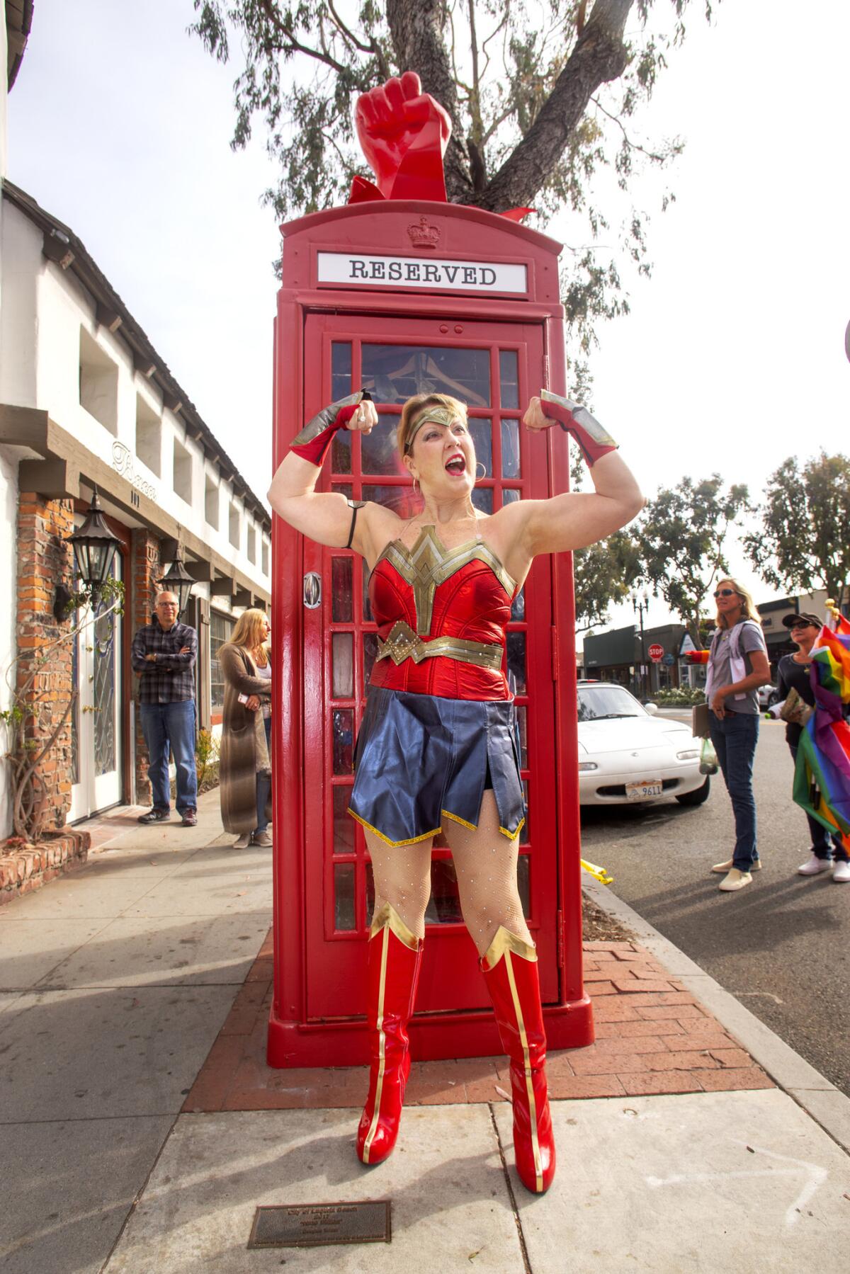 Heidi Miller, dressed as Wonder Woman, in front of Robert Holton's “Superhero Changing Station”
