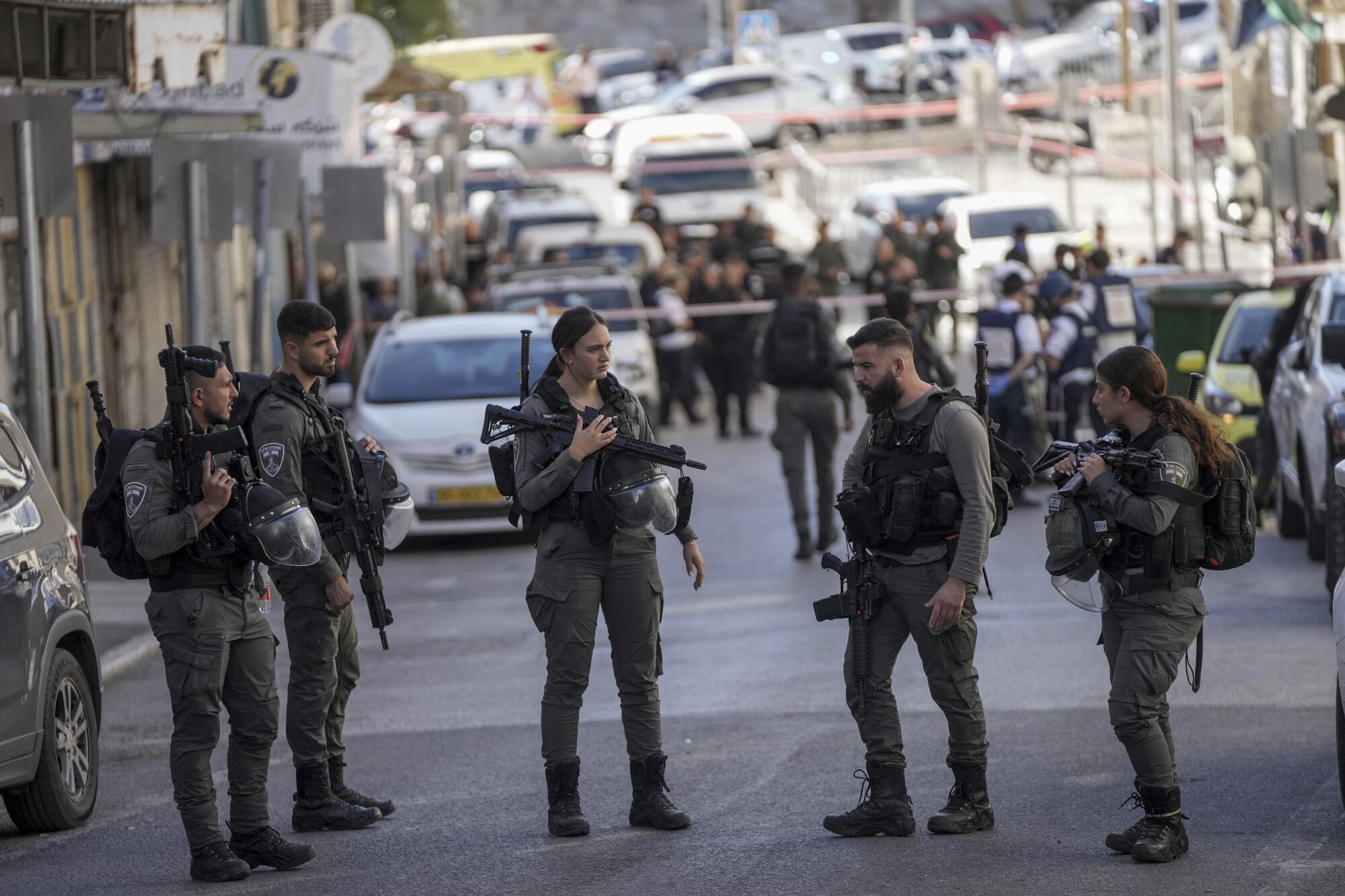 Several Israeli police officers stand in a street 