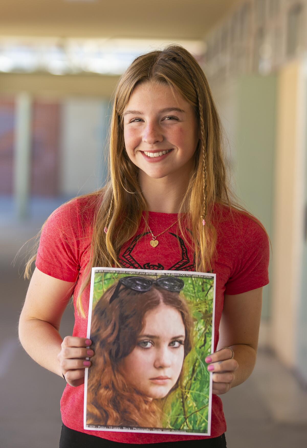 Costa Mesa student Allie Trask, 14, with a picture of the student she painted Polina.