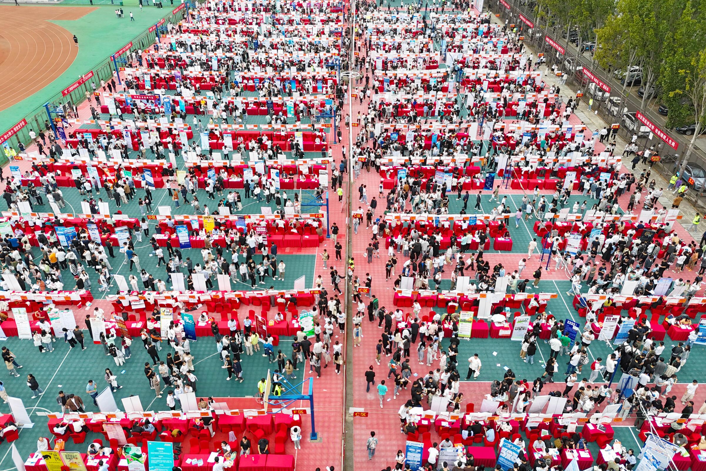 College students go to booths at a job fair at Shandong University of Science and Technology in Qingdao, China.