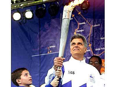 Former Olympic champion Mark Spitz holds the Olympic flame
