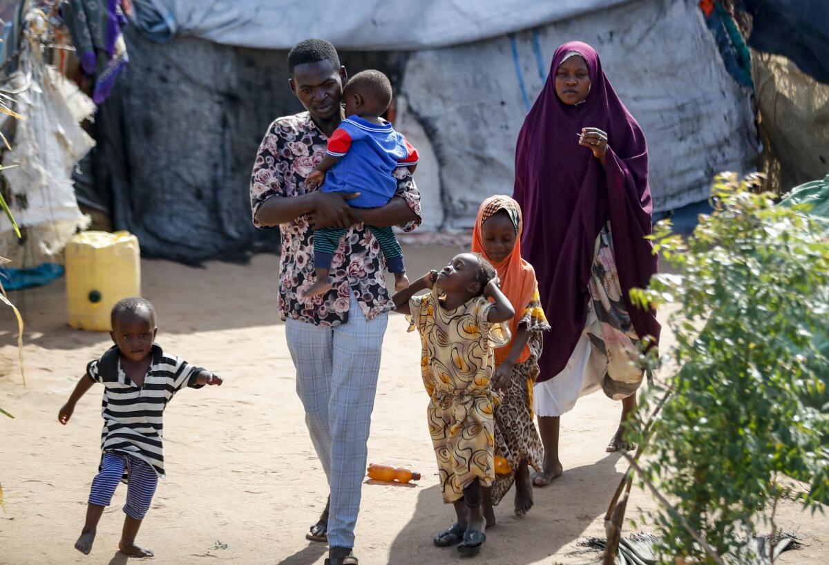 Abdikadir Omar walks to a shelter with his wife and children.