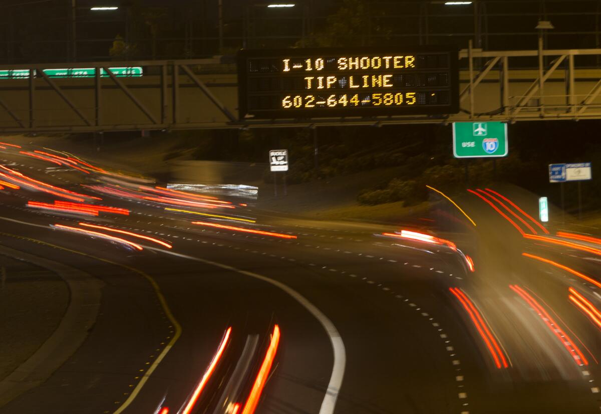 A sign displays a shooter tip hotline above Interstate 10 in Phoenix.