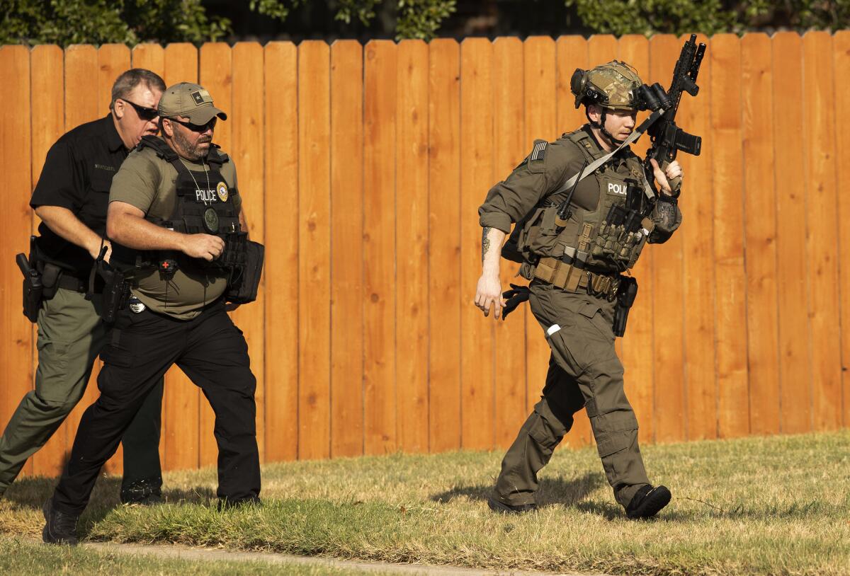 Police officers work near a house in Cedar Park, Texas