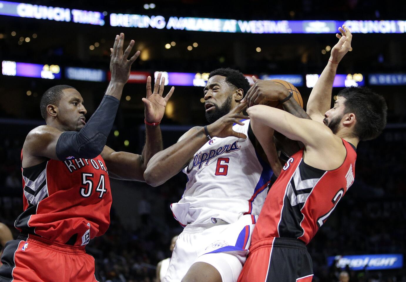 Clippers center DeAndre Jordan (6) tries to pull down a rebound between Raptors center Patrick Patterson (54) and guard Greivis Vasquez in the first half.