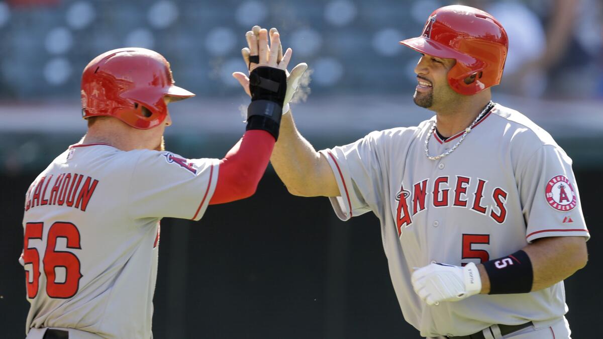 Angels first baseman Albert Pujols, right, is congratulated by right fielder Kole Calhoun after hitting a three-run home run during a 12-3 win over the Cleveland Indians on Monday.